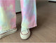 Tie-dye pants and white sneakers