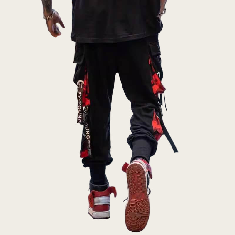 Person wearing black pants with red and white accents and red sneakers.