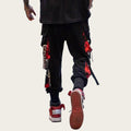 Person wearing black pants with red and white accents and red sneakers.