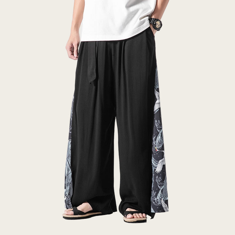 Person wearing black wide-leg pants with white patterns on a white background