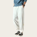 Person wearing white pants and black sneakers in a room.