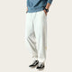 Person wearing white pants and black sneakers in a room.