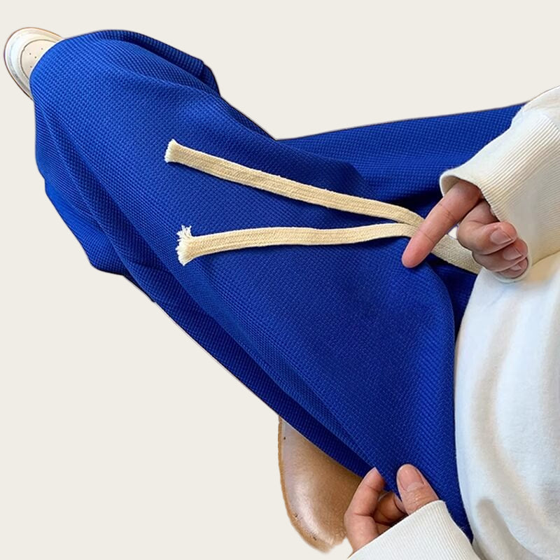 Person wearing blue sweatpants with white drawstrings.