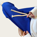 Person wearing blue sweatpants with white drawstrings.