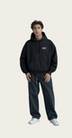 Person wearing a black hoodie and dark pants 
