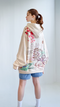 Woman wearing a colorful floral kimono-style garment against a white background