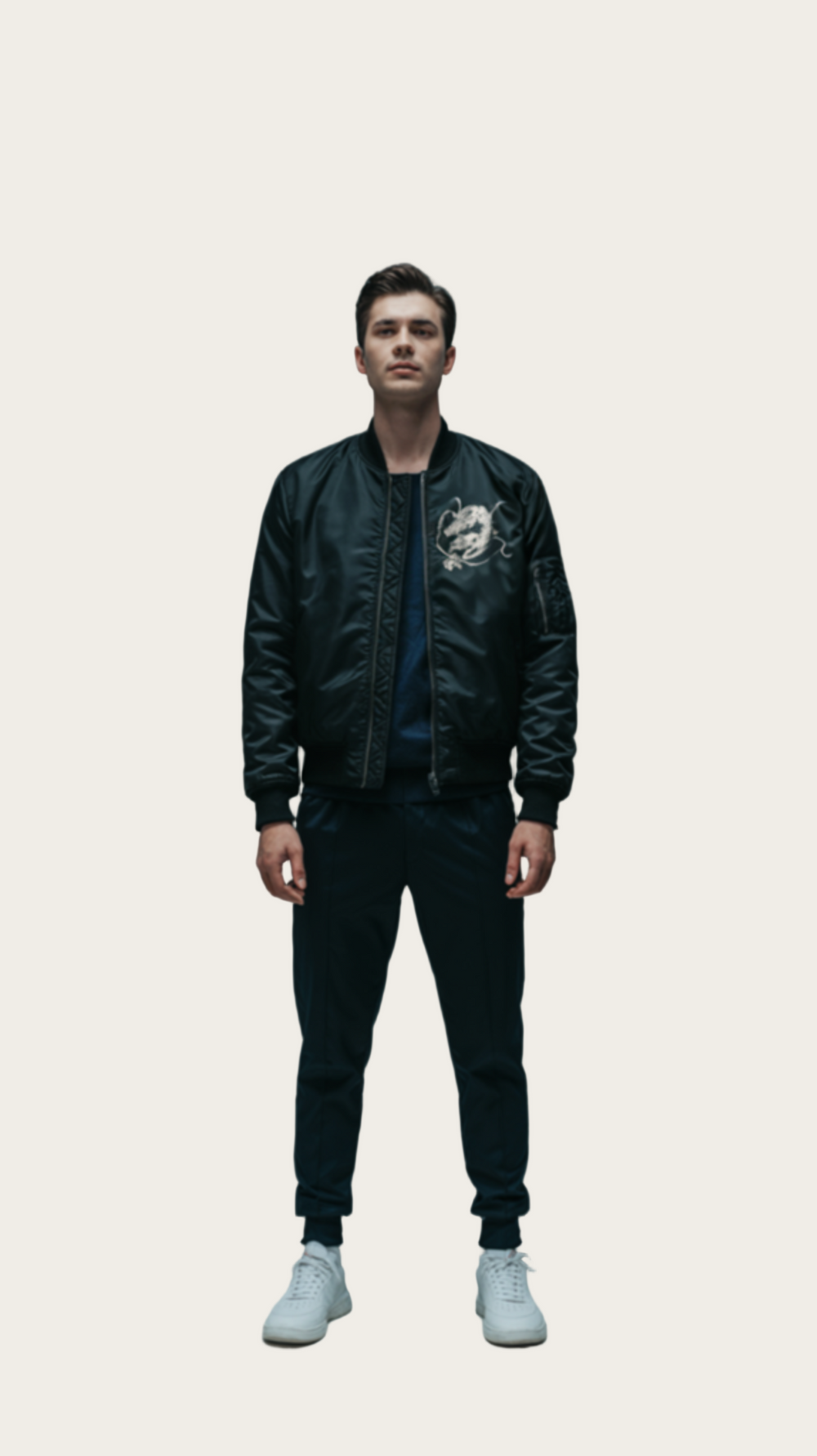 Person wearing a black bomber jacket with a logo on a gray background