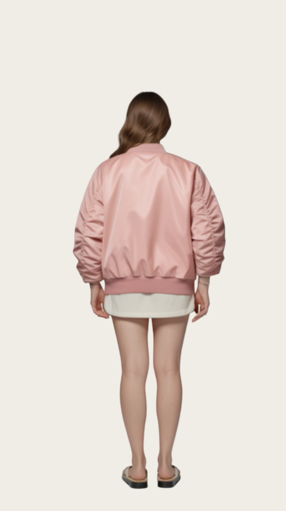Person wearing a pink bomber jacket and white shorts on a gray background