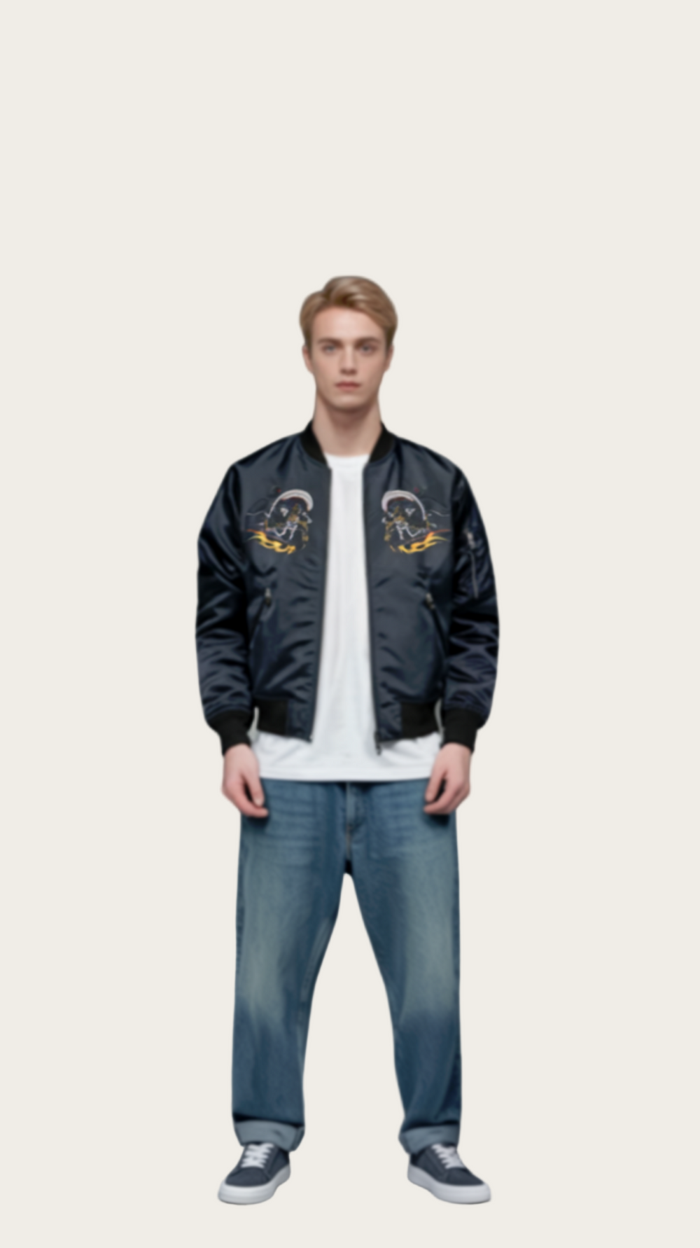 Man wearing a black bomber jacket with yellow designs, white shirt, blue jeans, and black shoes on a gray background
