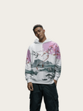 Person wearing a hoodie with a scenic design in a minimalistic setting