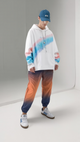 Person wearing a colorful hoodie and gradient pants with a blue cap on a neutral background