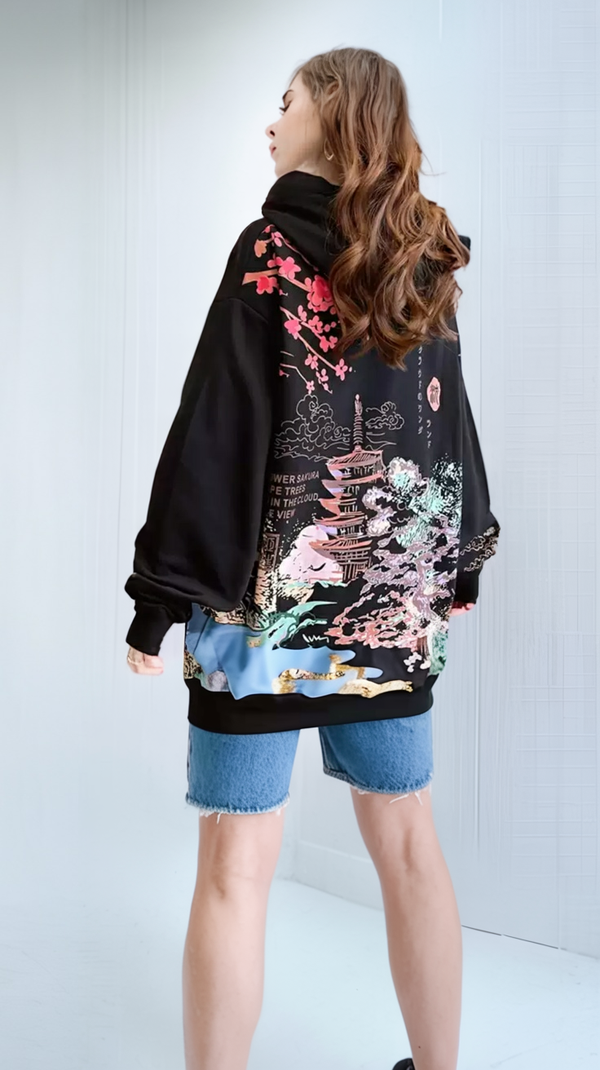 Person wearing a black sweater with colorful floral designs on a white background