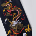 Embroidered dragon design on a black fabric background