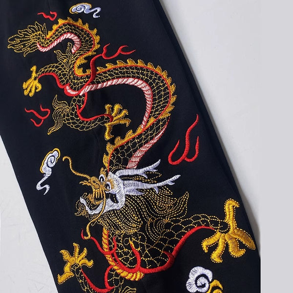 Embroidered dragon design on a black fabric background