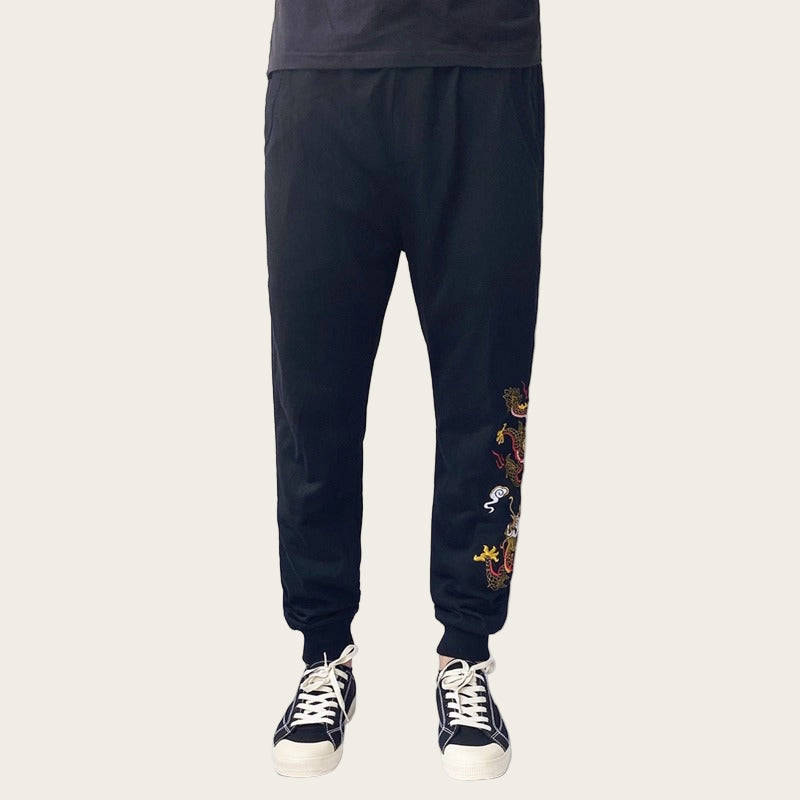 Black pants with dragon embroidery on a white background