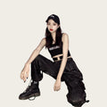 Person wearing a black tank top with 'ROCK MORE' text, black pants, and black shoes.