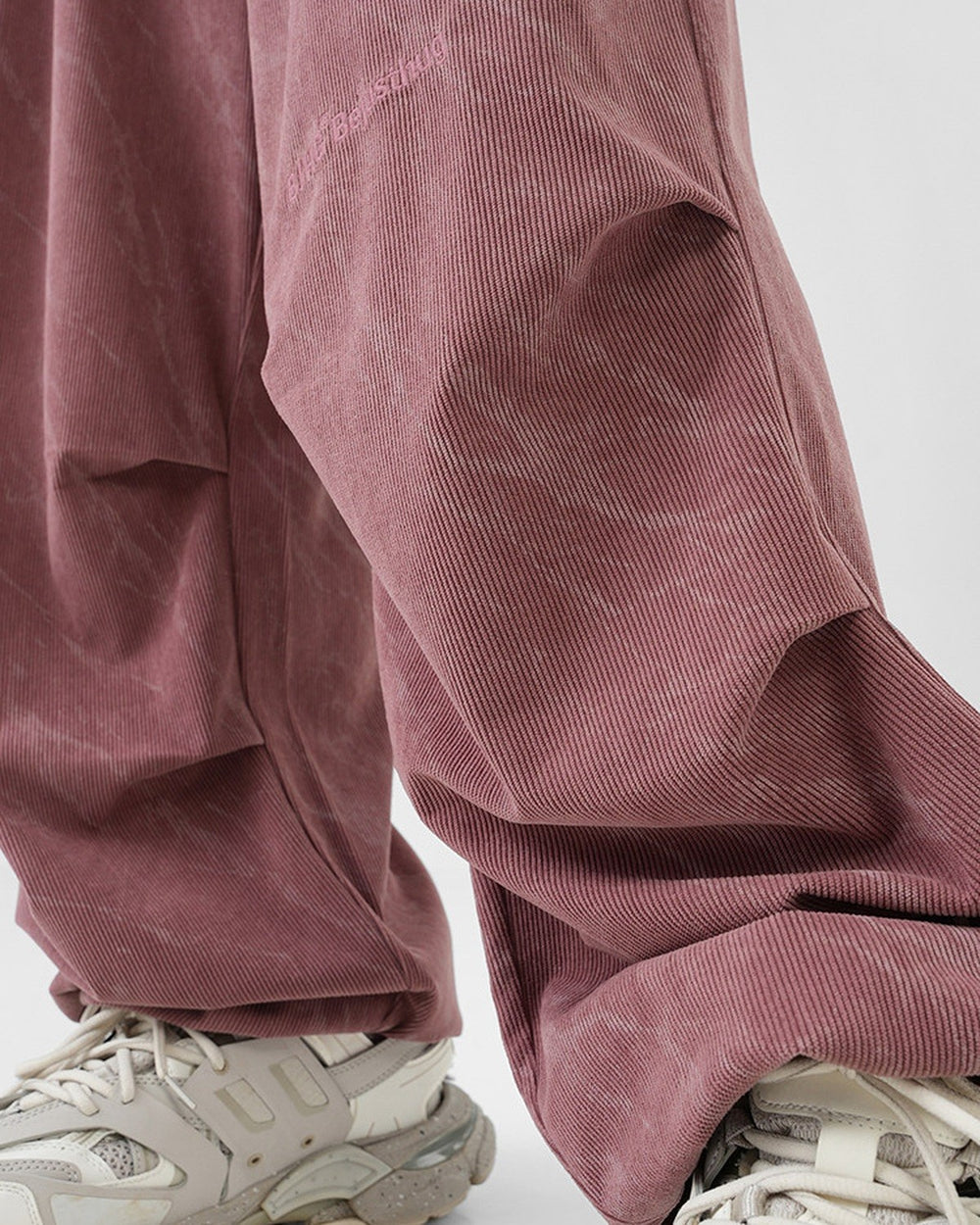 Close-up of the pleated knee on the pink corduroy pants