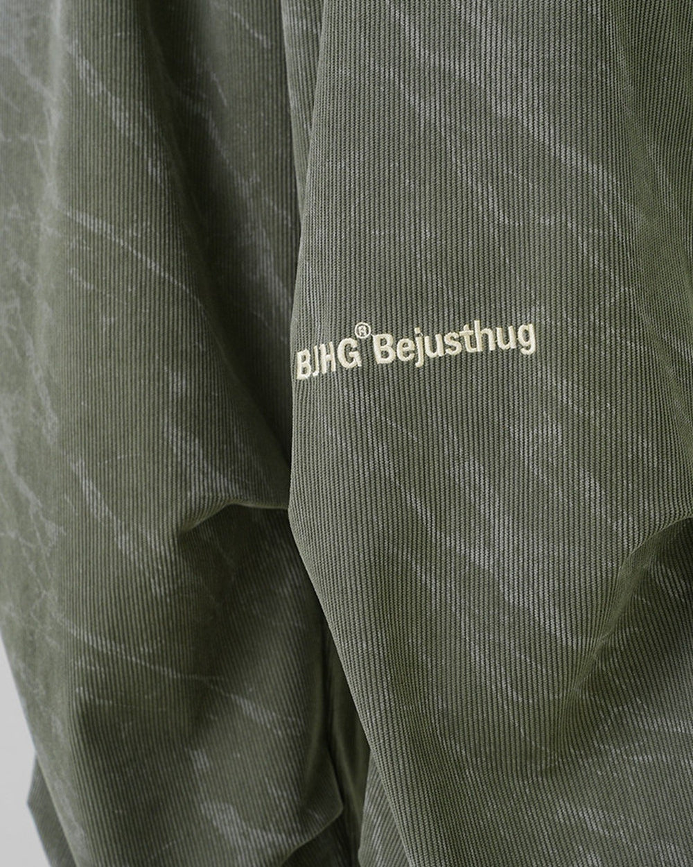 Close-up of the embroidered BJHG Bejusthug logo on the olive green pants