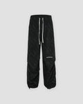 Black acid-wash corduroy parachute pants with a drawstring hem, front view