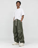 Model wearing the olive green corduroy parachute pants, three-quarter view