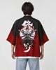 Man seen from behind in the black and red haori with a white character and a many-armed asura on the back