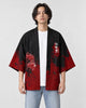 Man in the open black and red haori with vertical white characters on the chest, a white tee and light jeans