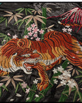 Close-up of the tiger among bamboo and pink blossoms under Mount Fuji