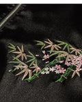 Close-up of the embroidered bamboo and blossom sprig on the chest