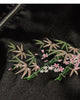 Close-up of the embroidered bamboo and blossom sprig on the chest