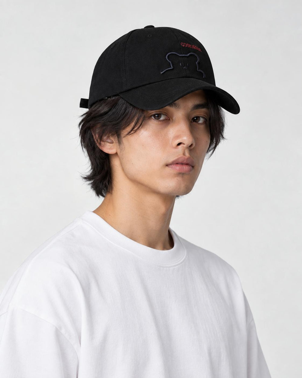 Model wearing the black bear baseball cap with a white tee, three-quarter view