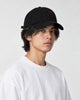 Model wearing the black bear baseball cap with a white tee, three-quarter view