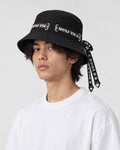 Model wearing the black ribbon bucket hat with a white tee, three-quarter view