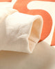 Close-up of the ribbed cuff and the printed letter on the sleeve