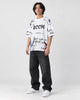 Model wearing the white BOOM graffiti print T-shirt, three-quarter view