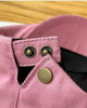 Close-up of the back strap of the pink flat cap with its two metal snaps