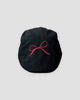 Black flat cap with a fine red bow embroidered on the crown