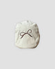 Cream flat cap with a fine dark brown bow embroidered on the crown