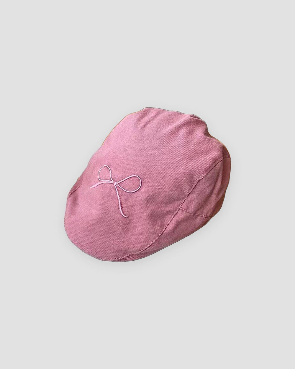 Pink flat cap with a fine pale pink bow embroidered on the crown