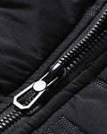 Close-up of the metal zip pull and the quilted fabric on the black jacket