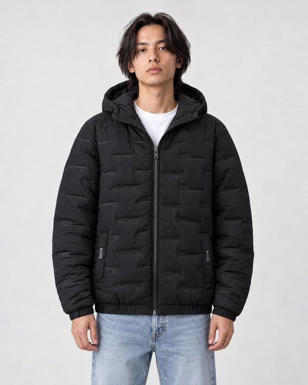 Model wearing the black quilted padded jacket zipped up over a white tee and light-wash jeans