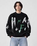 Model wearing the black brushstroke letter sweater with jeans, front view