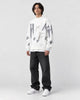 Model wearing the white brushstroke letter sweater, three-quarter view