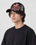 Model wearing the black butterfly embroidered cap, three-quarter view