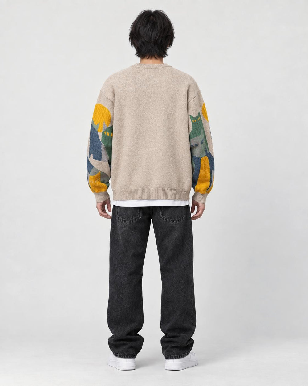 Model wearing the beige cat sweater, back view with the cats on the sleeves