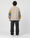 Model wearing the beige cat sweater, back view with the cats on the sleeves