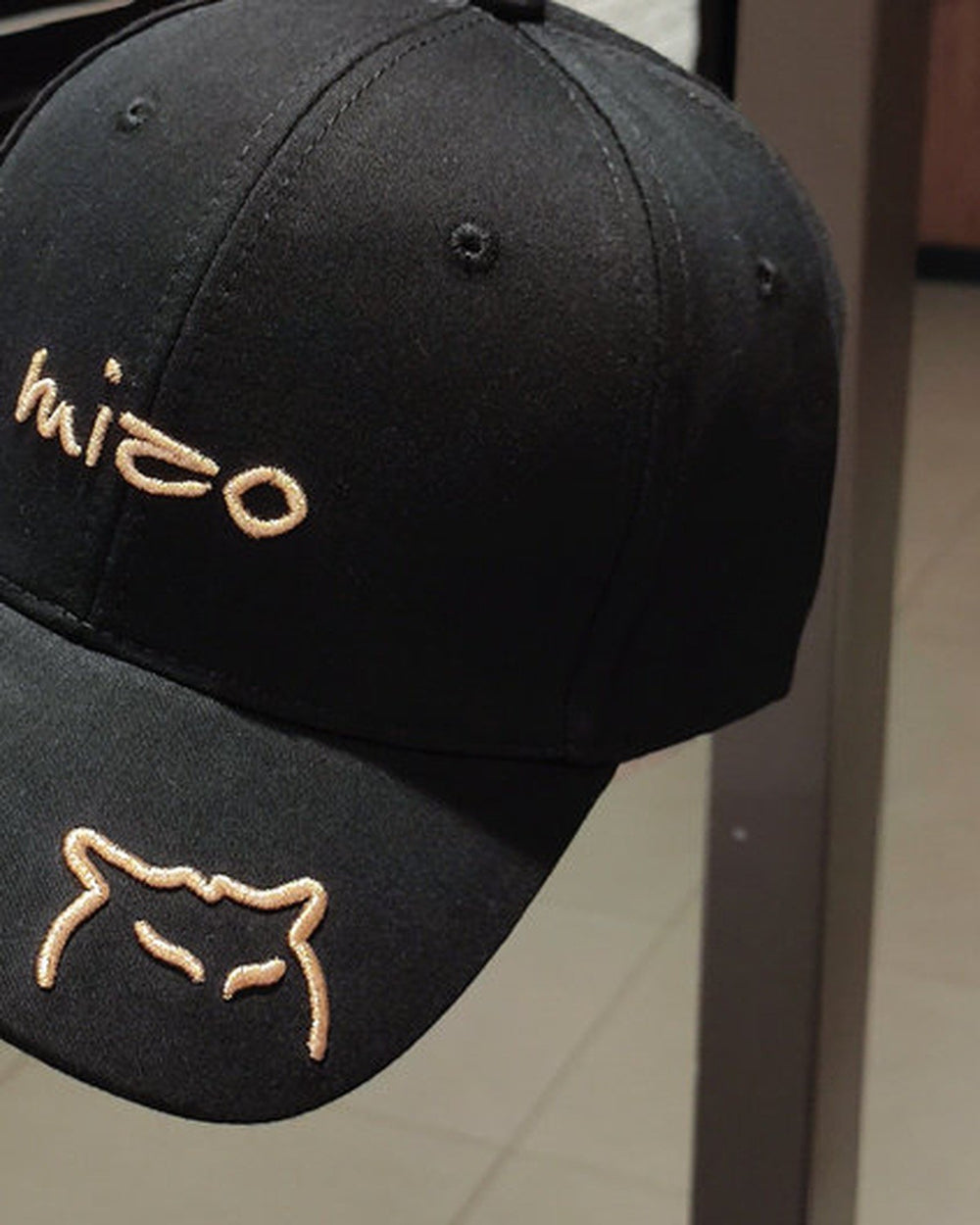 Close-up of the mizo lettering and the cat outline embroidered on the black cap