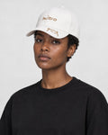 Model wearing the white mizo cat embroidered baseball cap with a black tee, side view