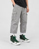Model wearing the green high-top sneakers with light gray cargo trousers, front view
