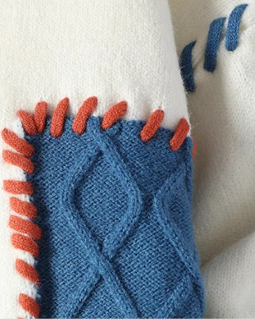 Close-up of the blue cable patch edged with orange whipstitching