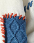 Close-up of the blue cable patch edged with orange whipstitching